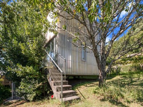 a house with stairs next to a tree at Treehouse in Galicia near Silgar Beach in Sanxenxo