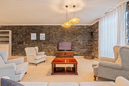 a living room with two chairs and a table at Villa Rosa Mare by Homie in Seixal