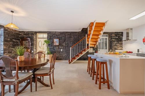 a kitchen and dining room with a wooden table and chairs at Villa Rosa Mare by Homie in Seixal