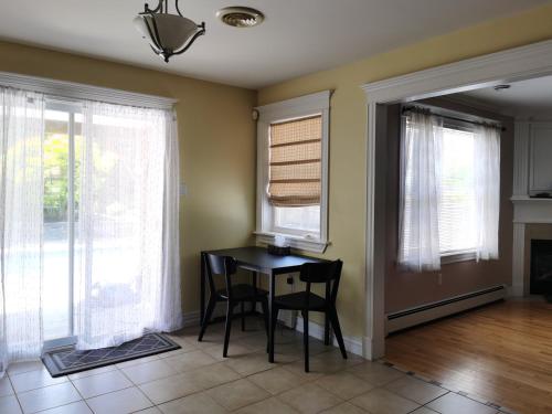 a dining room with a table and chairs and windows at Full Kitchen AC Share Bathroom #2 in Halifax
