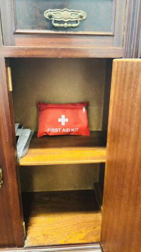 a red first aid pillow sitting on a shelf at Quarto com varanda no centro de viseu in Viseu