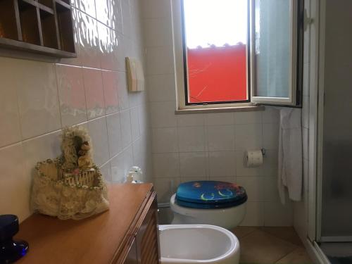 a bathroom with a toilet and a sink and a window at Villino Luce in Nettuno