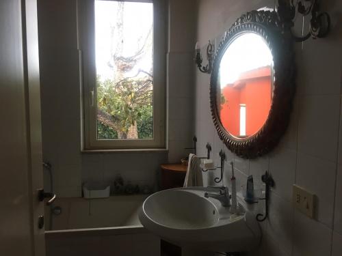 a bathroom with a sink and a mirror and a tub at Villino Luce in Nettuno