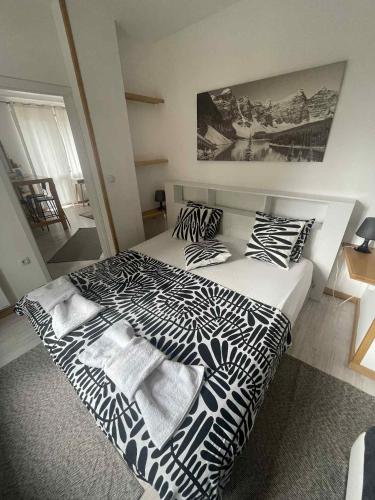 a bedroom with a bed with black and white sheets and pillows at Seasons stay Bansko in Bansko