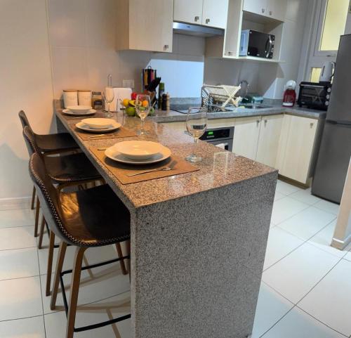 a kitchen with a table with glasses of wine at Moderno Dpto Vista al Mar y Piscina Temperada in La Serena