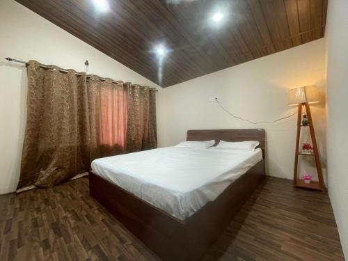 Cloudscape Cottage في شيملا: غرفة نوم فيها سرير ومصباح