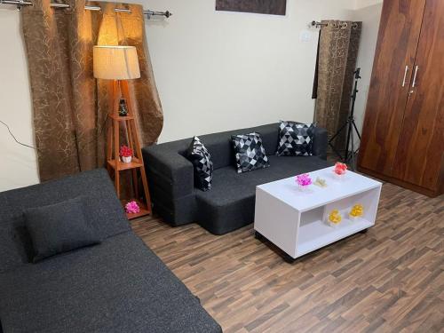 Cloudscape Cottage في شيملا: غرفة معيشة مع أريكة وطاولة قهوة