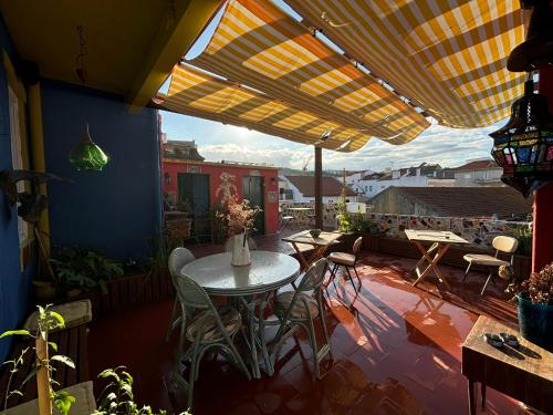 a patio with a table and chairs under an umbrella at Soul - Coliving in Vila Franca de Xira
