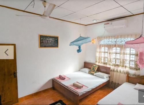 une petite pièce avec un lit et une fenêtre dans l'établissement ANINA resort mirissa, à Mirissa