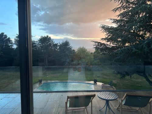 a view of a swimming pool from a window at La coutoisière in Millery
