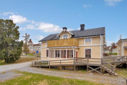 une grande maison jaune avec un toit noir dans l'établissement HernöRum - Rum i Villa Fiskekroken, à Härnösand