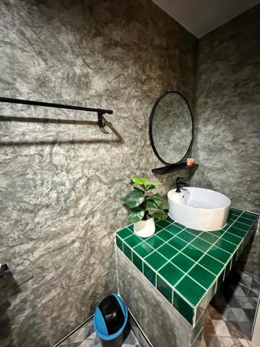 a bathroom with a sink and a mirror at นิวพีเคซี รีสอร์ต in Prakhon Chai