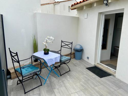 a table and two chairs on a patio at Maisonnette cosy au calme terrasse local vélo in Rochefort