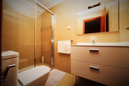 a bathroom with a shower and a toilet and a sink at Casa da Portada in São Vicente