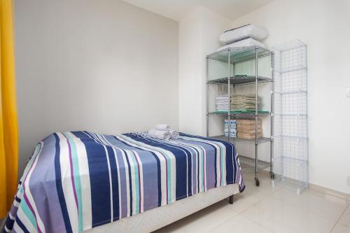 Un dormitorio con una cama con una manta a rayas. en CF · Cabo Frio Relax!, en Cabo Frío