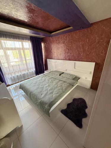 a small bedroom with a bed with a white bed frame at LADA Apartment in Nesebar
