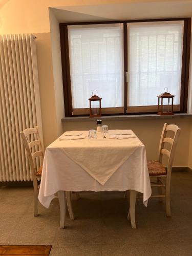 a table with two chairs and a white table cloth at B&B Piccolo Relais in Lessolo