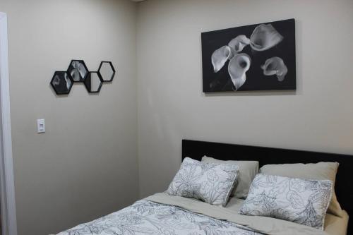 une chambre avec un lit et un tableau au mur dans l'établissement Tranquille pond facing suite, à Nisku