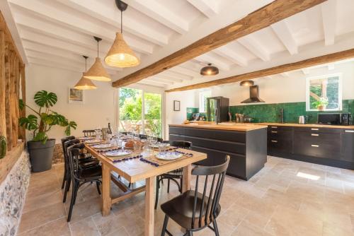 a dining room with a wooden table and chairs at Sublime Longère Le Garden, 10 voyageurs, 2 terrasses, terrain de Basket in Triqueville