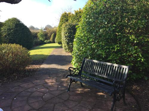 a park bench sitting on a brick walk way at Four Seasons Hotel & Leisure Club in Monaghan