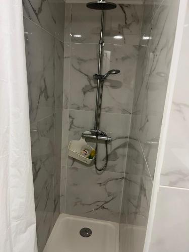 a shower with a glass door in a bathroom at Duplex no estoril in Estoril