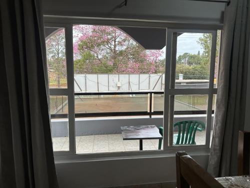 a window with a view of a garden outside at Departamento amueblado con Cine, balcón y céntrico in Bella Vista