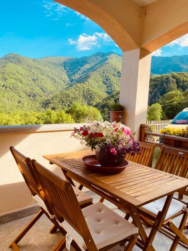 a wooden table with a vase of flowers on a porch at Luce sul Bric in Gambasca