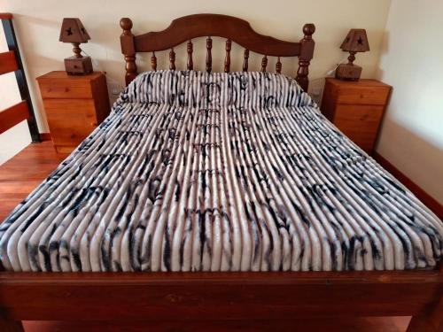 a bed with a wooden headboard and two night stands at La Palmera in Chajarí