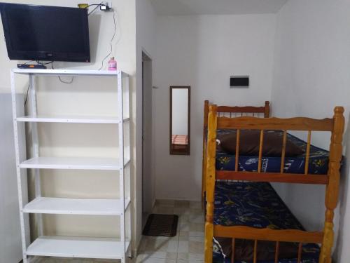 a room with two bunk beds and a television at Chalés Bielle de Ubatuba in Ubatuba