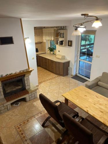 a living room with a fireplace and a table and chairs at Dom nad samym Bugiem 2h od Warszawy in Klepaczew