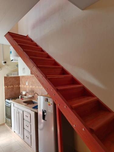 a staircase in a kitchen with a stainless steel refrigerator at La Palmera in Chajarí