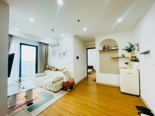 ein Wohnzimmer mit einer weißen Couch und einer Küche in der Unterkunft Love House - Căn hộ 2 phòng ngủ tại Nera Garden Huế in Thôn Văn Dương