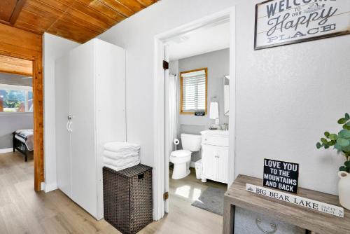 a bathroom with a toilet and a sign that says welcome to the happy place at Jay bird landing escape #2308 in Big Bear City