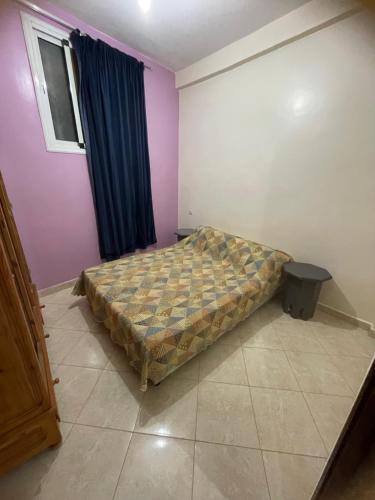 Un dormitorio con una cama en la esquina de una habitación. en Aghrod Boud, en Tamri