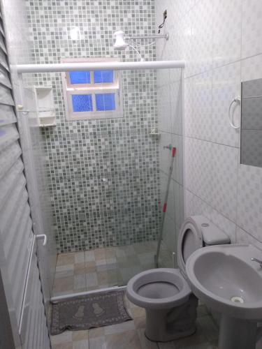 a bathroom with a shower and a toilet and a sink at Chalés Bielle de Ubatuba in Ubatuba
