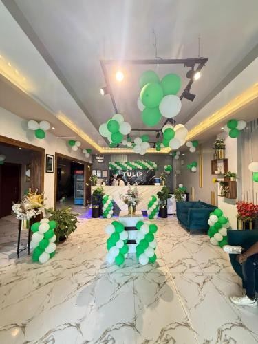 a lobby with green and white balloons on the ceiling at Tulip Hotel in Karachi