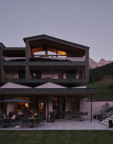 a large building with people sitting at tables at Neueröffnung ELVA PREMIUM APARTMENT HOTEL inklusive Sommerpass STUBAI SUPER CARD in Neustift im Stubaital