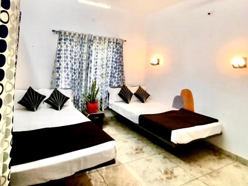 Cette chambre comprend deux lits et une chaise. dans l'établissement Chembani Holidays and Resorts Kanthalloor, à Kanthalloor