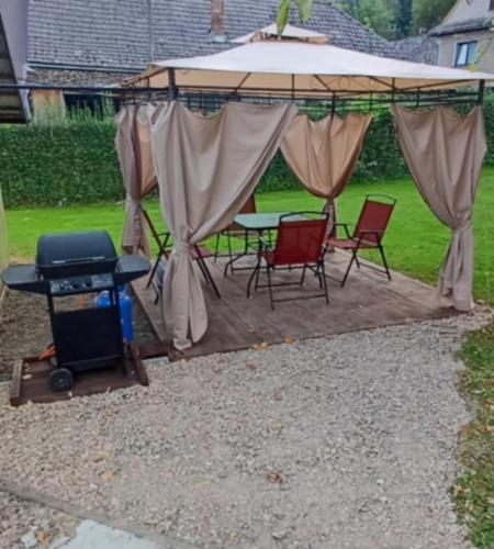 a gazebo with chairs and a table and a grill at Pod Górą in Wiśniowa