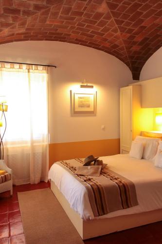 a bedroom with a bed with a brick ceiling at Herdade Do Sobroso Wine & Luxury Boutique Hotel in Pedrógão