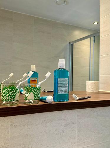 a bathroom counter with a bottle of mouthwash and a mirror at Riverside Figs in Manchester