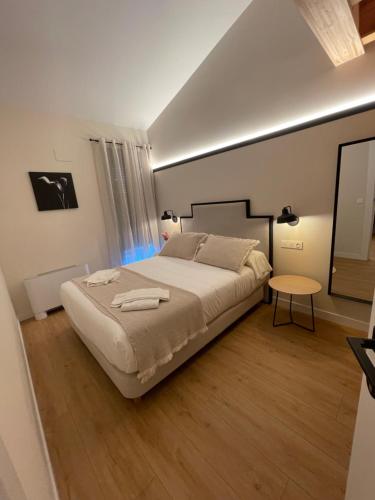 a bedroom with a large bed and a table at Hotel Apartamento Los Villares in Los Villares de Soria