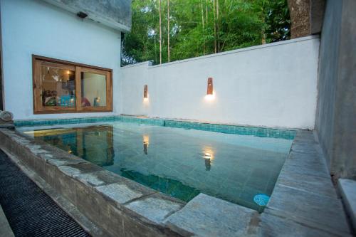 a swimming pool in the middle of a house at Percy Residence in Unawatuna