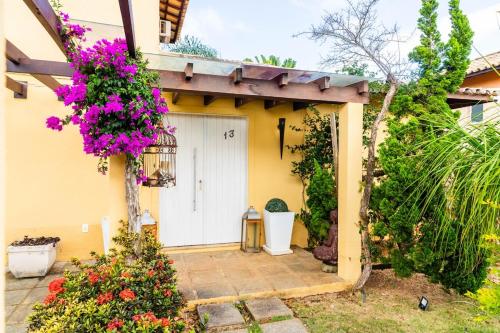 a house with a white door and flowers at Buzios VIP in Búzios
