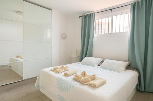 アデへにあるApartment in Ocean Park, Costa Adeje, Tenerifeのベッドとタオル2枚のある寝室