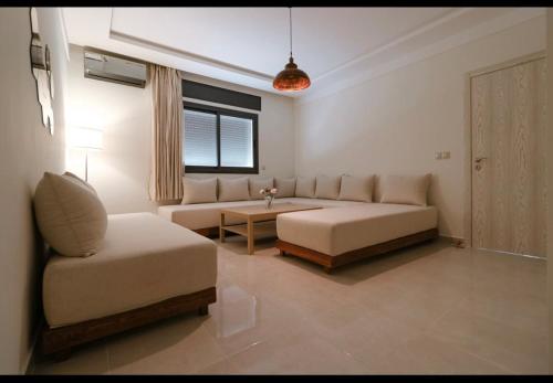 a living room with a couch and a table at Modern Neubau Apartment 3 Klima WLAN Beach in M'diq