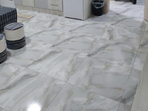 a white marble floor in a room with two trash cans at Mara in Prokuplje