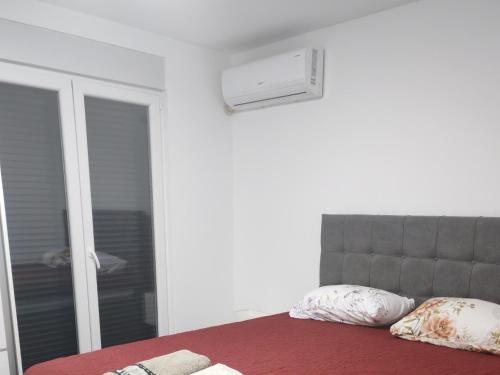 a bedroom with a bed with a window and a mirror at TARA apartman in Pojate