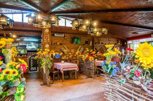a restaurant with tables and flowers in a room at Kolyba House in Kyiv