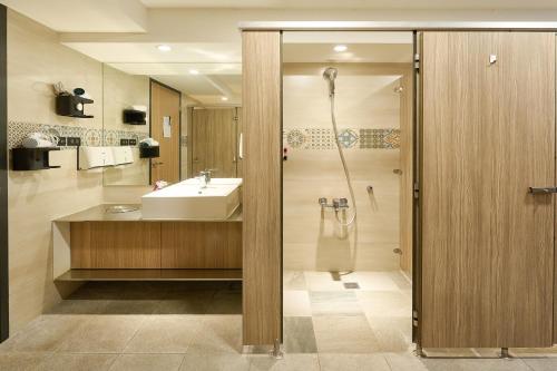 a bathroom with a sink and a shower at Doudian DDiNN Hotel in Taichung